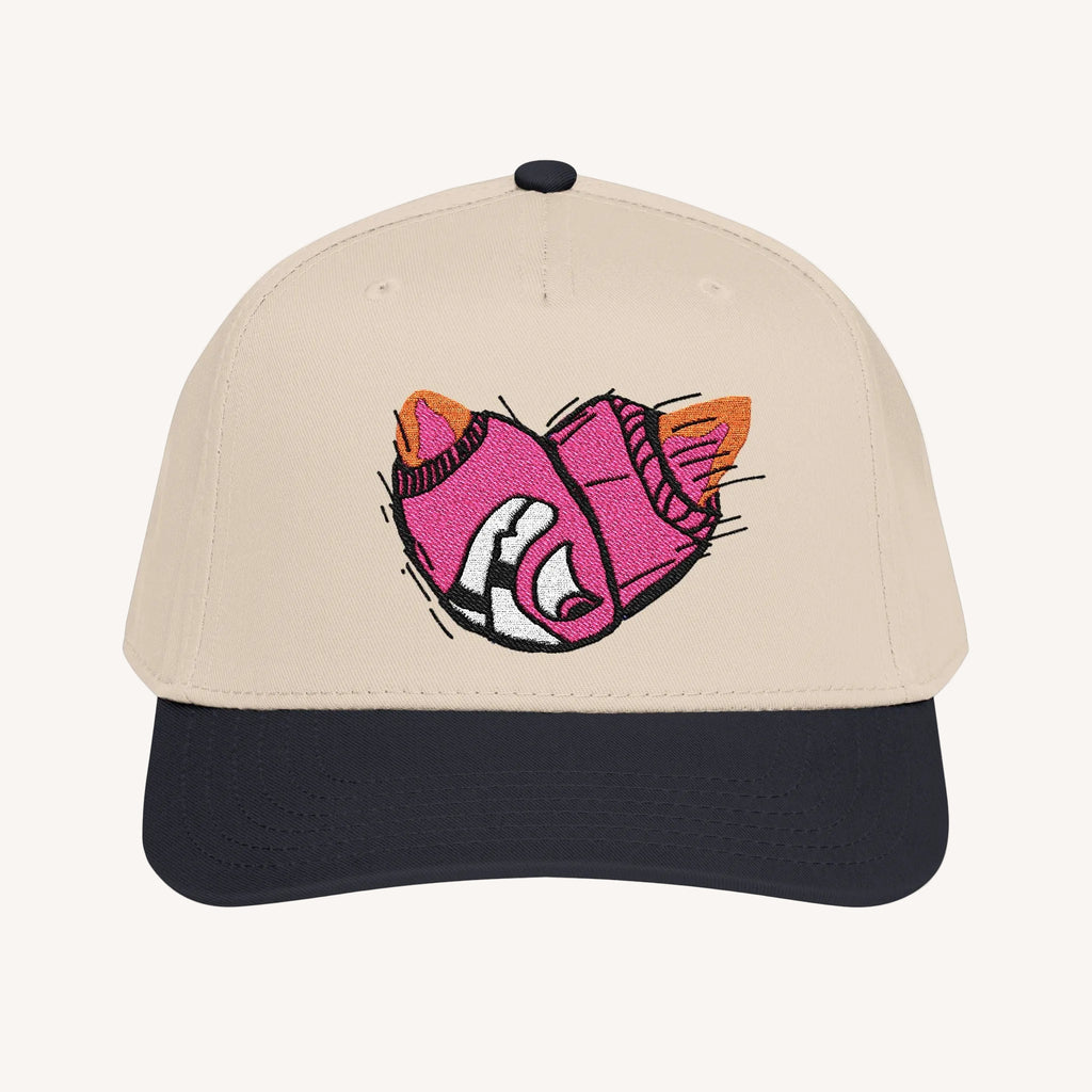 Beige cap with a pink and black Bomb face design on a white background