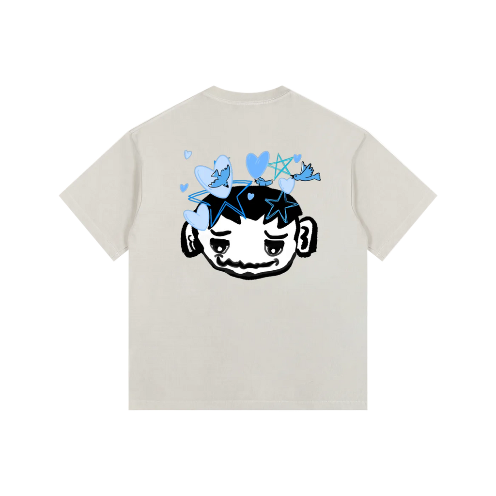 Beige t-shirt with a graphic design on the back featuring a face with stars and blue butterflies on a white background.