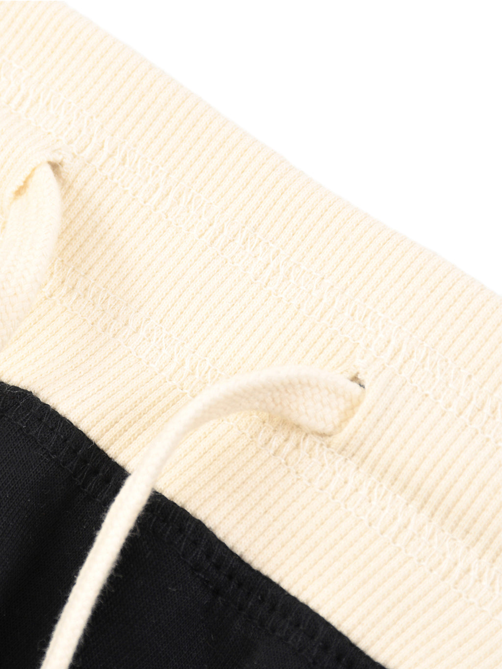 Close-up of a black and beige woven bag with a strap.