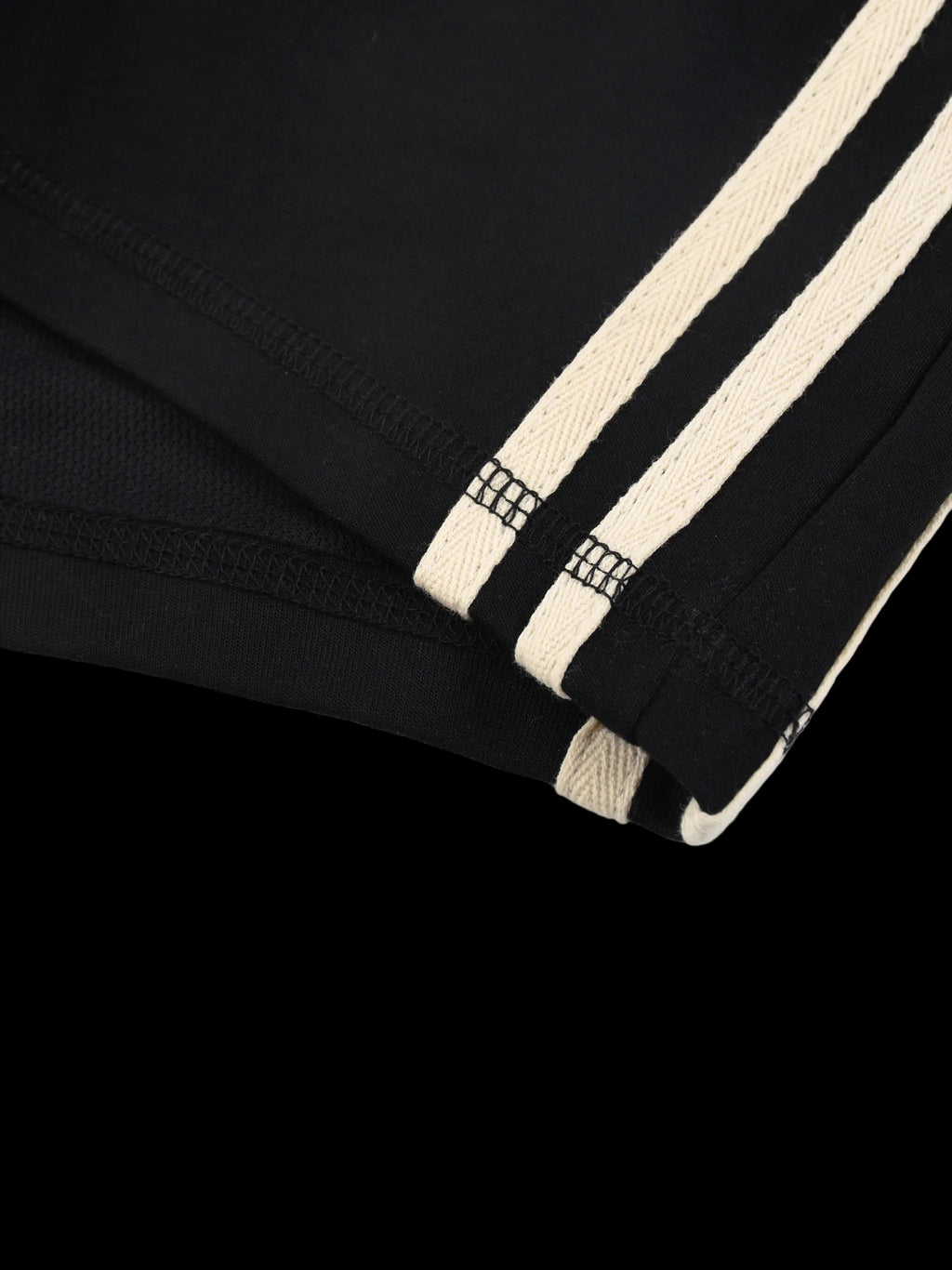 Close-up of a black garment with beige stripes on a white background